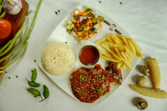 A meal with chicken, rice, fries, salad, and sauce.